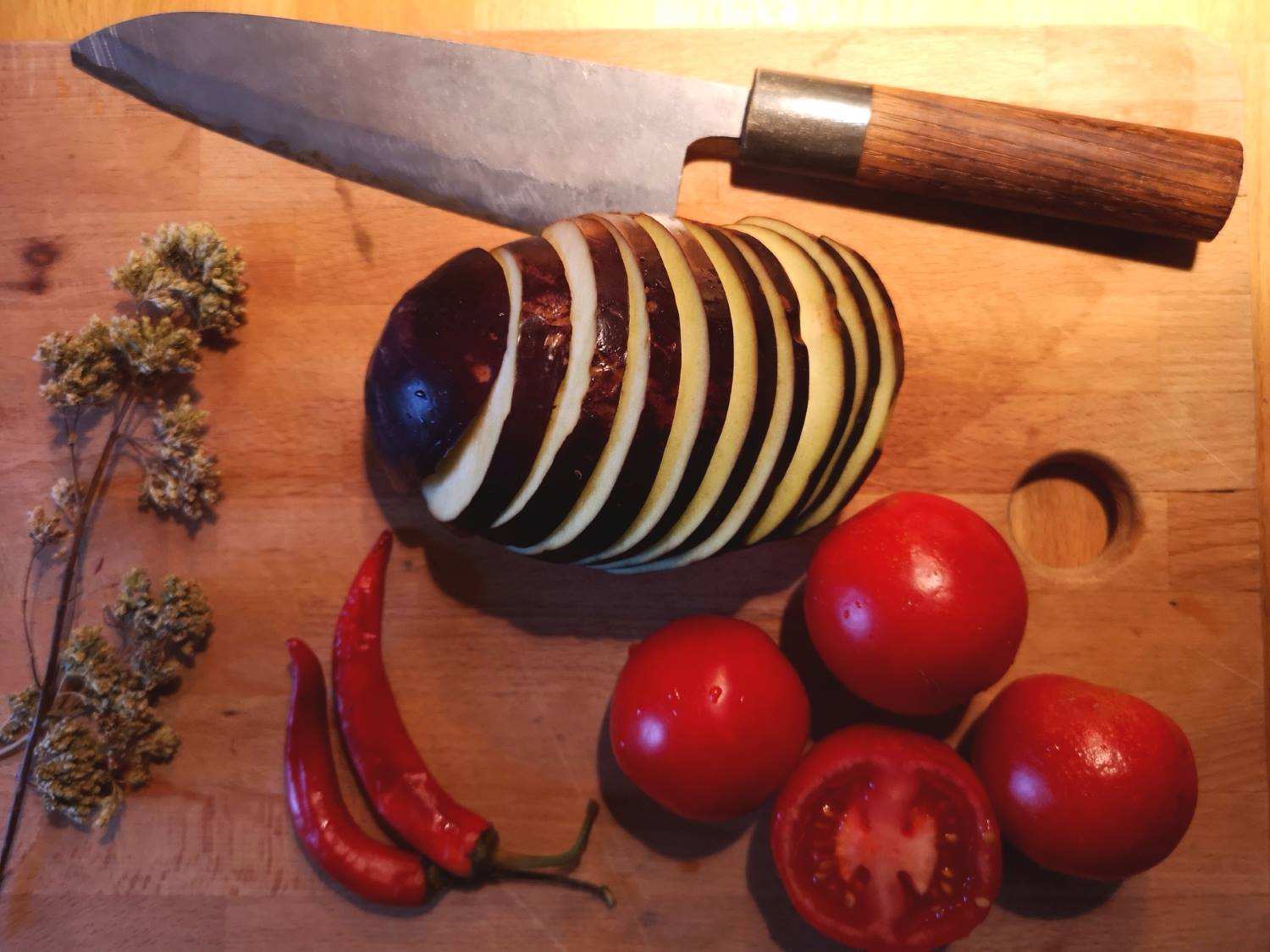 Aubergine und Tomate auf einem Holzbrett geschnitten